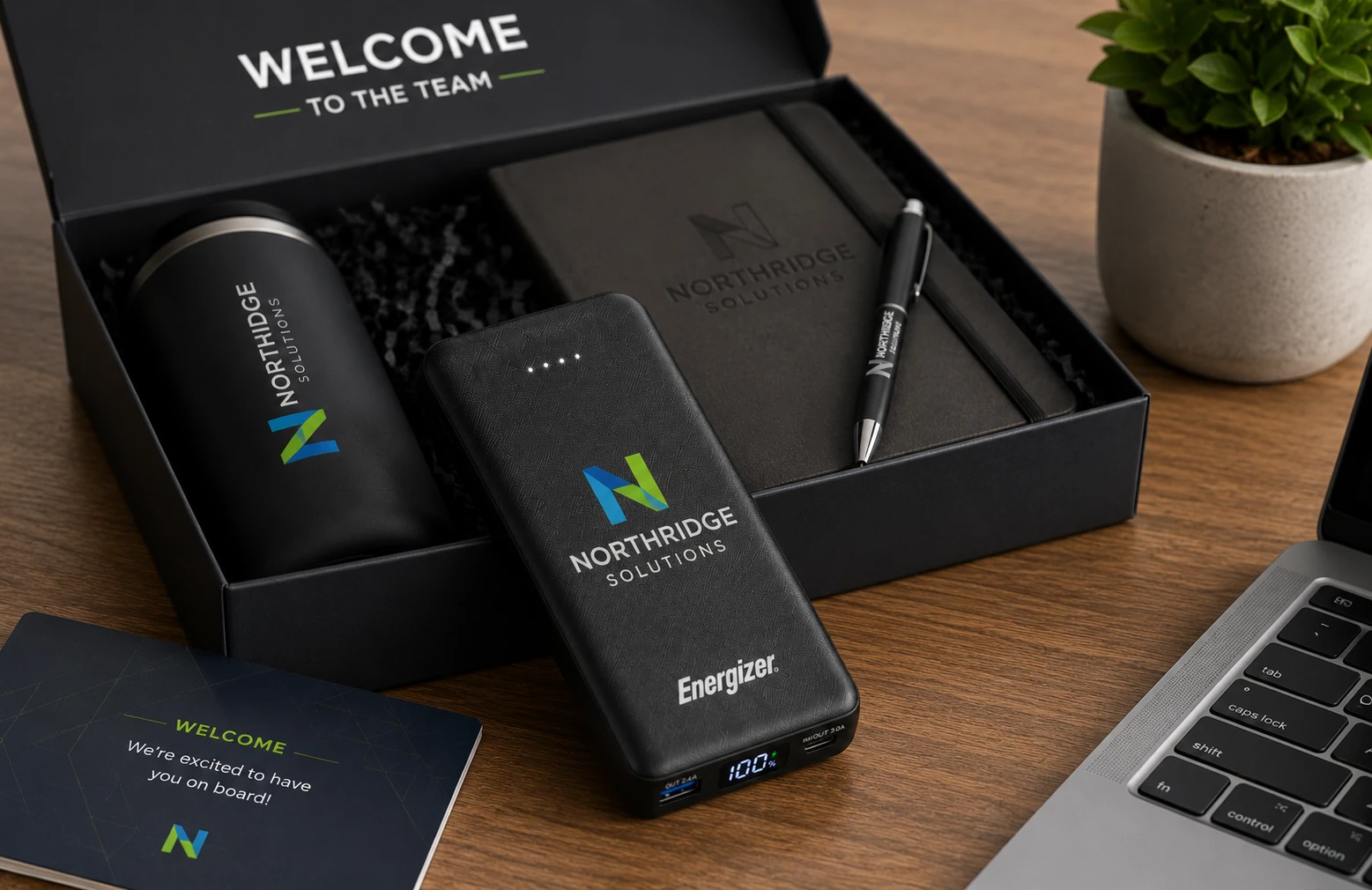 Branded Energizer power bank in a corporate onboarding welcome kit beside a laptop